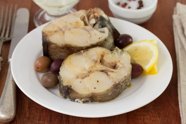 Boiled fish with lemon and olives — Stock Photo, Image