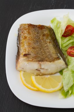 Tabağında taze salata olan balık.