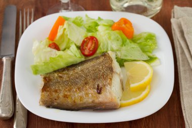 Tabağında taze salata olan balık.