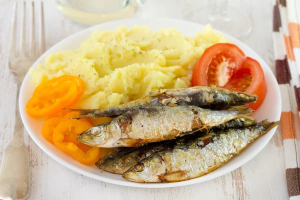 Stekta sardiner med potatis på tallriken — Stockfoto
