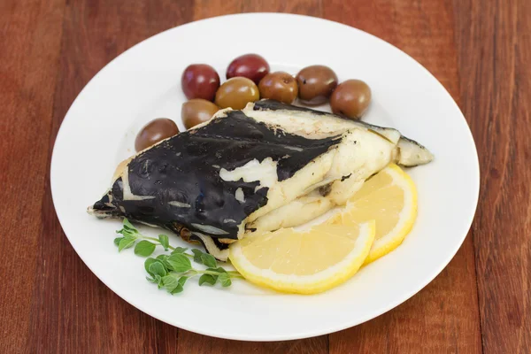 Peixe com azeitonas e limão em prato branco — Fotografia de Stock