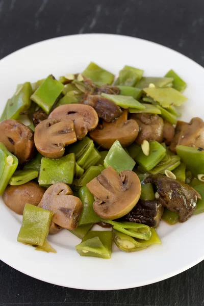 Beans with mushrooms on white plate — Stock Photo, Image