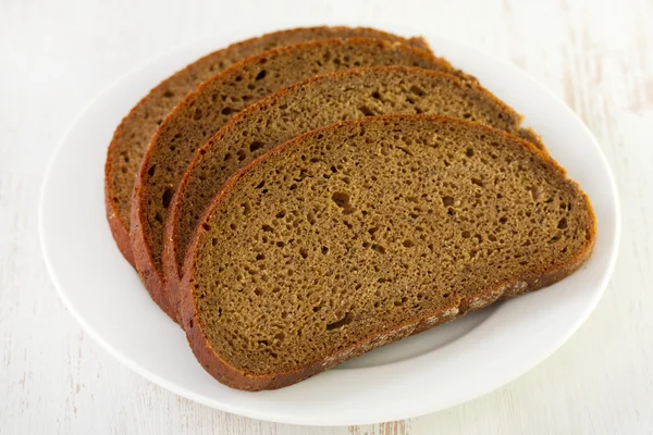 Pão escuro no prato — Fotografia de Stock
