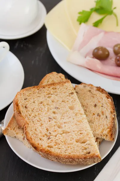 Bröd på tallrik med ost och skinka — Stockfoto