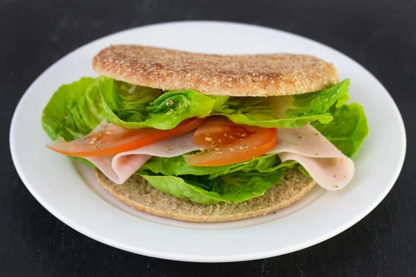 Smörgås med skinka och sallad på tallrik — Stockfoto