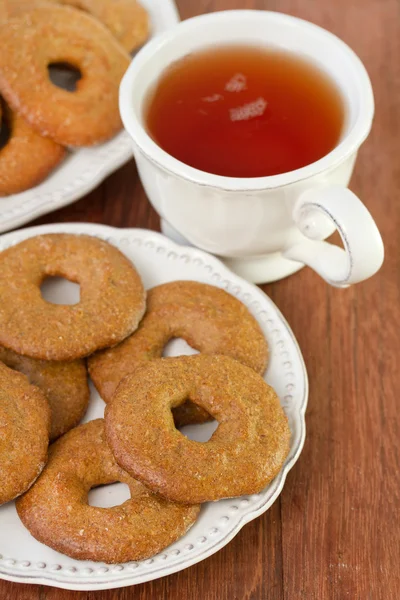 Soubory cookie na desce s šálkem čaje — Stock fotografie