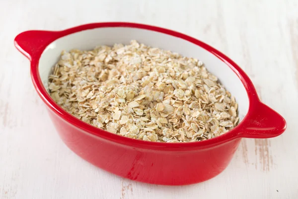 Oatmeal in red bowl — Stock Photo, Image