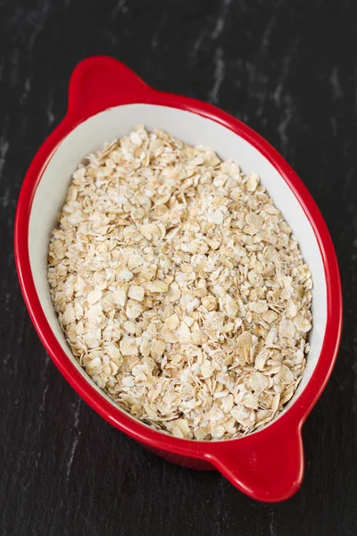 Oatmeal in red bowl — Stock Photo, Image