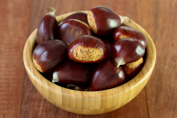 Castagne in ciotola su sfondo marrone — Foto Stock