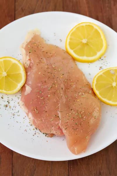 Chicken breast with lemon on plate — Stock Photo, Image