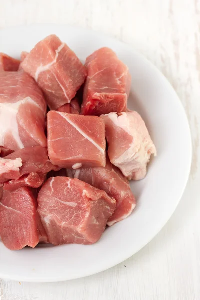 Carne di maiale su piatto bianco su sfondo bianco — Foto Stock