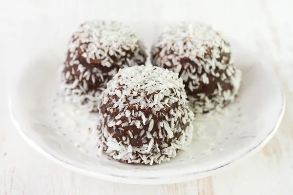 Dulces de coco de chocolate en plato blanco —  Fotos de Stock