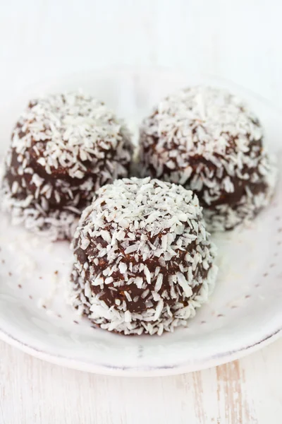 Шоколадные кокосовые конфеты на белой тарелке — стоковое фото