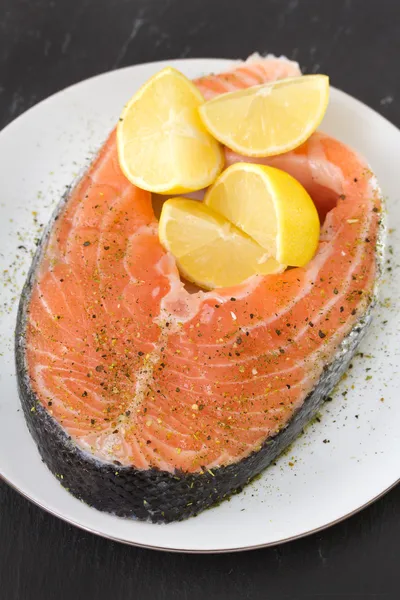 Salmón fresco con limón en plato blanco —  Fotos de Stock