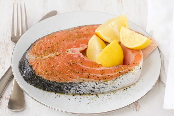 Salmón fresco con limón en plato blanco —  Fotos de Stock