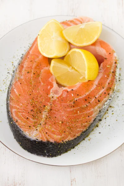 Salmón fresco con limón en plato blanco —  Fotos de Stock