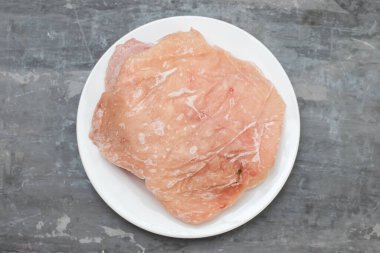 Küçük beyaz tabakta donmuş et hindisi.