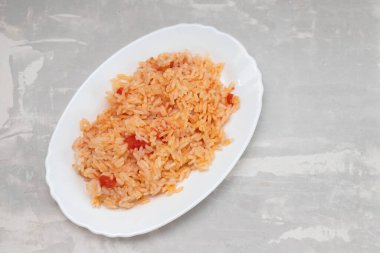 Domatesli pilav ve seramik tabakta baharat.