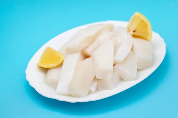 Bläckfisk Med Peppar Och Färsk Citron Vit Skål Blå Bakgrund — Stockfoto
