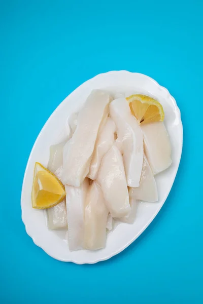 Roher Tintenfisch Mit Pfeffer Und Frischer Zitrone Auf Weißem Teller — Stockfoto