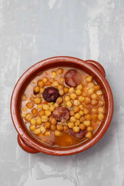 用熏腊肠和肉在褐色瓷壶里的小鸡豆 — 图库照片
