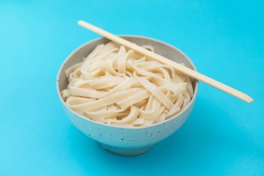 Haşlanmış erişte Udon mavi kağıt üzerinde seramik kase