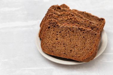 Beyaz küçük tabakta seramik üzerinde taze siyah ekmek