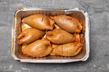 Doldurulmuş mürekkep balıkları beyaz tabakta seramik üzerine sos.