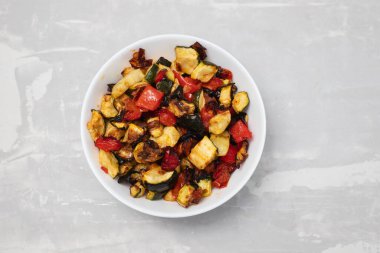 Izgara kabak, biber ve domates seramik üzerinde küçük beyaz kase