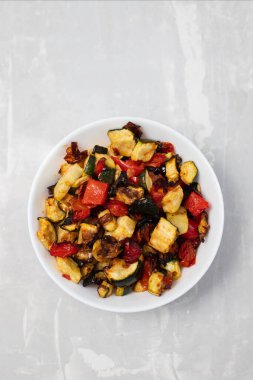 Izgara kabak, biber ve domates seramik üzerinde küçük beyaz kase