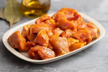 Küçük tabakta biber soslu çiğ domuz eti ve gri seramik.