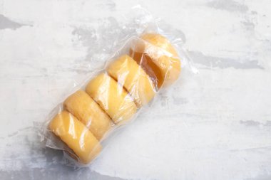 Seramik üzerinde küçük plastik torbalarda beş küçük peynir.