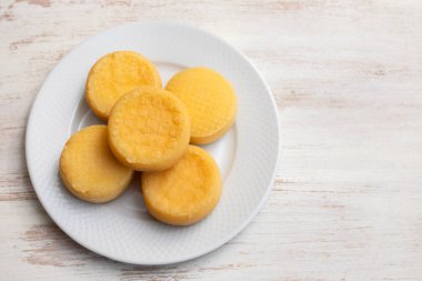 Beyaz ahşap üzerinde küçük beyaz tabakta beş küçük peynir