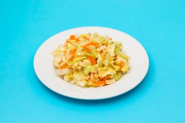 salad fresh cabbage with carrot on white dish on blue