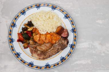 Sebzeli ızgara et ve tabakta pirinç.