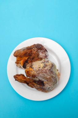 Donmuş ızgara tavuk ve beyaz tabakta buz.