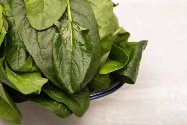 Gri seramik üzerinde taze yeşil ıspanak