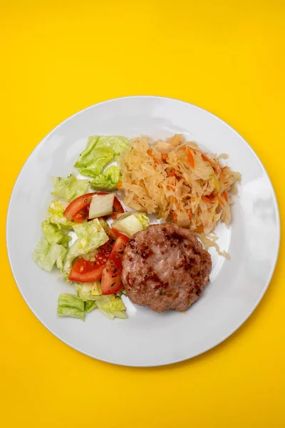 Grillowany Hamburger Sałatką Soloną Kapustą Salasową Marchewką Białym Talerzu Żółtym — Zdjęcie stockowe