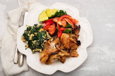 Kızarmış tavuk, yumurta ve ıspanak, taze salata.