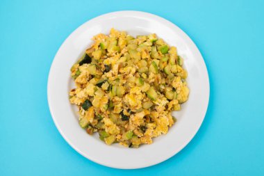 Çırpılmış yumurta ve kabak. Mavi üzerine beyaz küçük tabak.