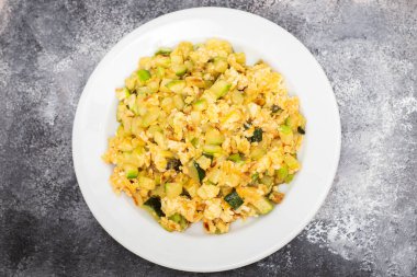 Çırpılmış yumurta ve kabak, gri üzerine beyaz küçük tabak.