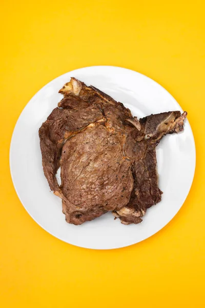 Grilled fresh meat on big gray dish on yellow — Stock Photo, Image