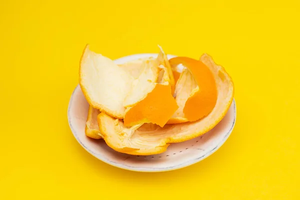 Свежая оранжевая мандаринская кожура на белом блюде — стоковое фото