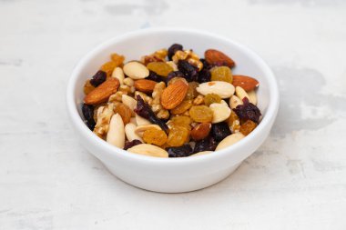 Kuru meyveleri gri seramik üzerinde küçük bir kasede karıştır