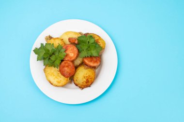 Beyaz tabakta kızarmış patates ve füme sosis.