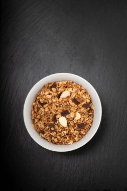 Siyah seramik üzerinde fındıklı müsli ve çikolatalı.