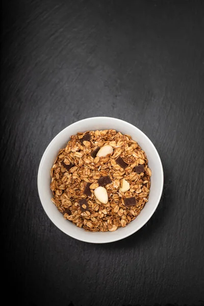 Siyah seramik üzerinde fındıklı müsli ve çikolatalı.