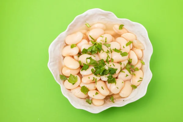 Boiled big white beans with sauce on white bowl — Stock fotografie