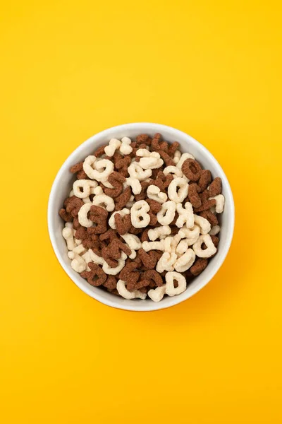 Simple and chocolate cereals letters in orange bowl — Stock fotografie