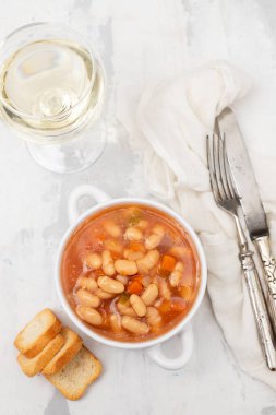 Sebzeli haşlanmış fasulye ve seramikte beyaz kâse üzerine sos.